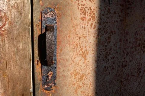 Rusty door handle and latch that is worn and broken. Stock-Fotos