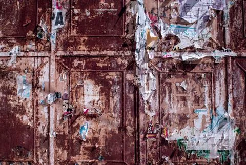 Rusty doors with old torn ads and posters, grunge vintage background 库存照片