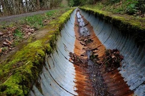 A rusty drainage pipe with moss Stock Photos