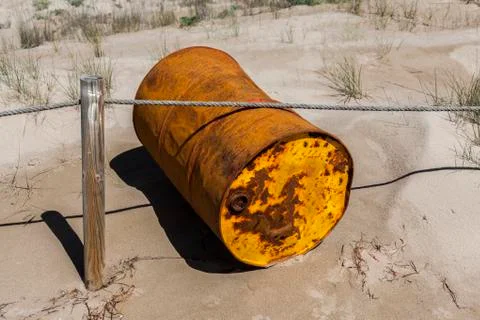 Rusty drum by the beach. Stock Photos