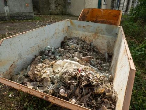 Rusty Dumpster Filled with Broken Clear Glass and Debris Stock Photos