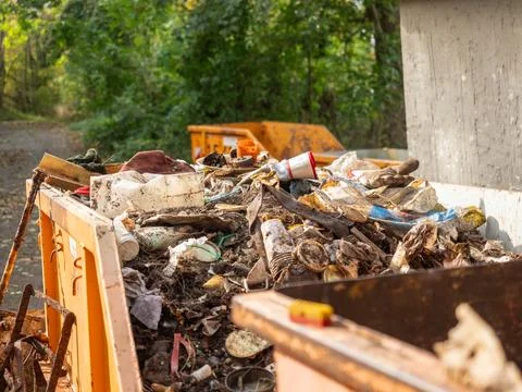 Rusty Dumpster Filled with Soil and Mixed Plastic Waste Stock Photos