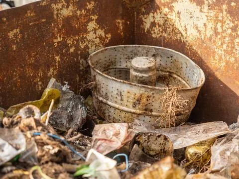 Rusty Dumpster Filled with Soil and Mixed Plastic Waste Stock Photos