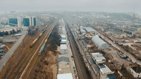 A rusty electric train moves along urban garages, like a slums. Stock Footage 130026056