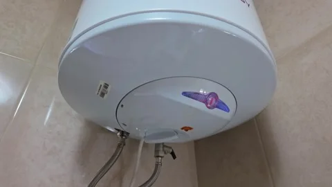Rusty electric water heater leaking from tank with moisture around plumbing Stock Footage 337507493