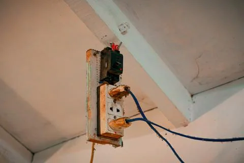 Rusty electrical socket with exposed wires on the ceiling Stock Photos