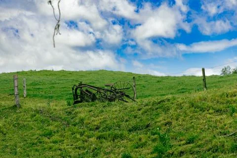 Rusty Farm Implement Rolling Green Pasture Foto stock
