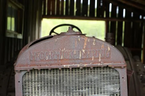 A rusty farm tractor in a barn Stock Photos