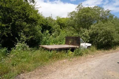 Rusty flatbed truck broken down and hitting on side of dirt road Stock Photos