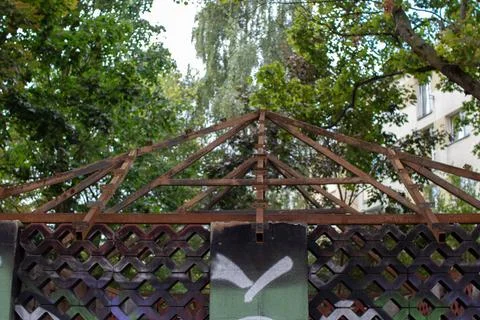 Rusty framework of a park shelter surrounded by trees in an urban area Stock Photos