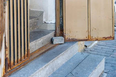 Rusty gate leans against stone steps Stock Photos