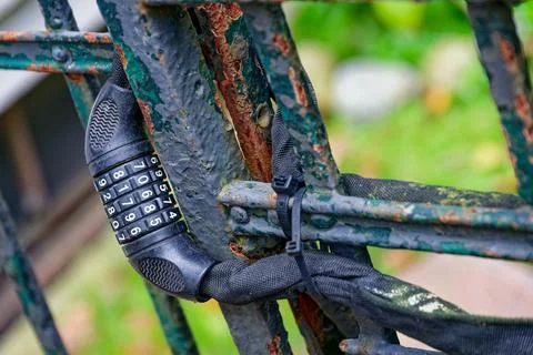 Rusty gate secured with five digit combination bicycle lock Stock Photos