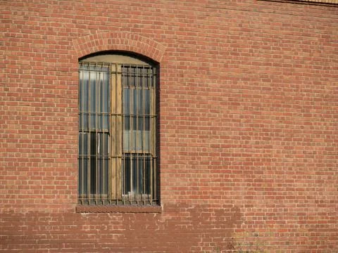 Rusty gated window outside of brick warehouse Stock Photos