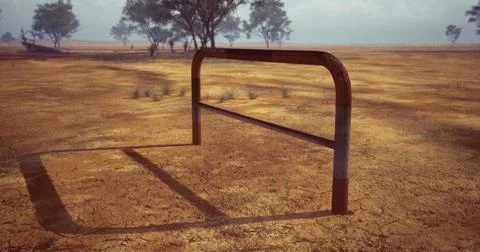 Rusty goal post stands alone in a dry, cracked field under a cloudy sky Stock Illustration