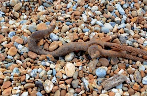 Rusty hook and cable on shingle Stock Photos