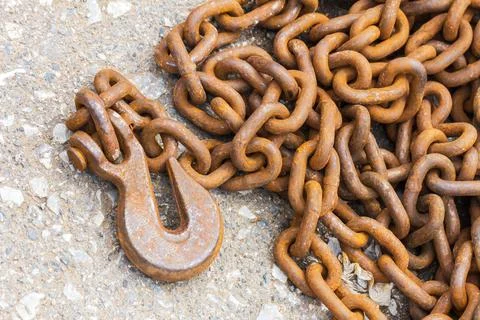 Rusty hook and chain on floor Stock Photos