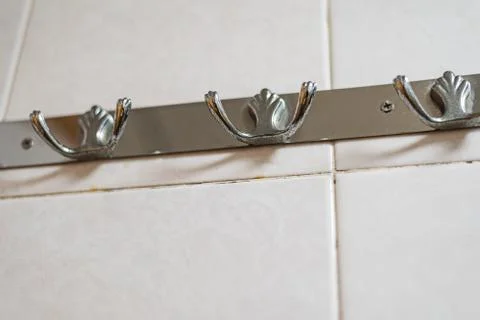Rusty hook up, bathroom, hanging, white background, ceramic tile Stock Photos