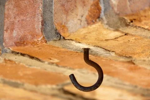 Rusty hook in a brick masonry Stock Photos