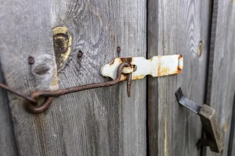 Rusty hook locks the wooden gate of an old barn Stock Photos