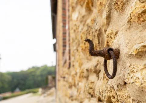 A rusty hook on a wall of limestone different view Stock Photos