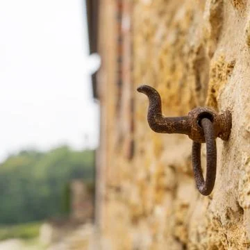 A rusty hook on a wall of limestone Stock Photos