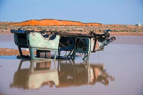 .rusty inverted car in the puddle after the flood in the desert of tunisia Stock Photos