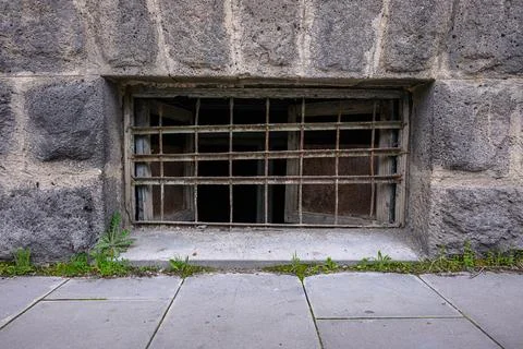 Rusty iron bars secure broken glass in stone wall Stock Photos