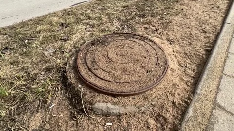 A rusty iron hatch covered grains of sand and the ground with a pattern above an Stock Footage 301135171