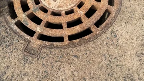 A rusty iron hatch with a pattern above an observation well is located on auto Stock Footage 274418195