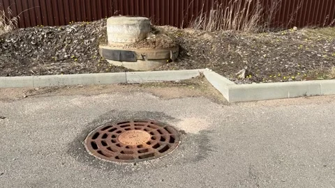 A rusty iron hatch with a pattern above an observation well is located on auto Stock Footage 299617859