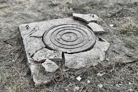 A rusty iron hatch with a pattern and a large gap at the top is mounted in a Stock Photos