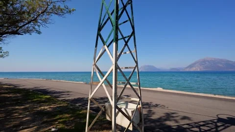 Rusty Iron Lighthouse on a Beach with Mountains in View Stock Footage 304686821