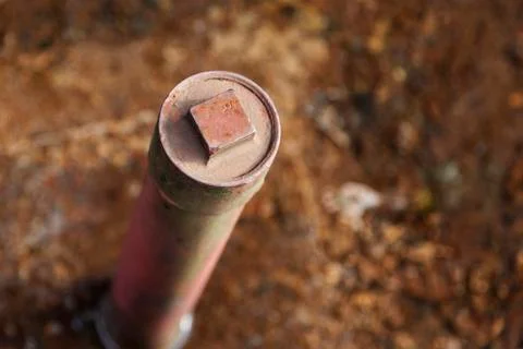 Rusty iron pipe which is stuck in the ground and stands straight up Stock Photos