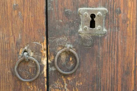 Rusty iron ring door knobs and keyhole over an old wooden grunge door Fotos de archivo