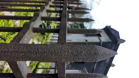 Rusty iron spike fence protecting a gravestone. vertica video Stock Footage 330993550