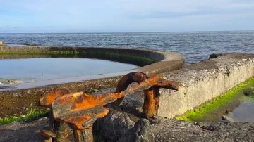 Rusty item and old pools in the sea Stockbeeldmateriaal 85823485