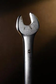 Rusty key in the dark with a yellow ray of light on the background Stock Photos