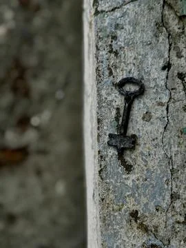 Rusty Key Embedded in Weathered Concrete Stock Photos