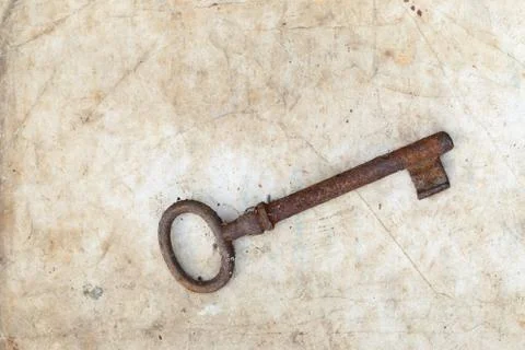 Rusty key on old parchment Stock Photos