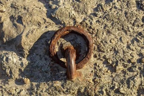 Rusty lashing ring on harbour wall Stock Photos