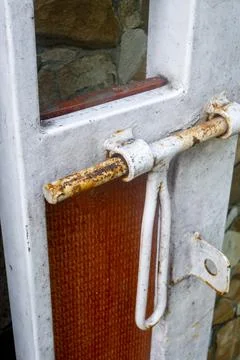 Rusty latch on the white house gate Stock Photos