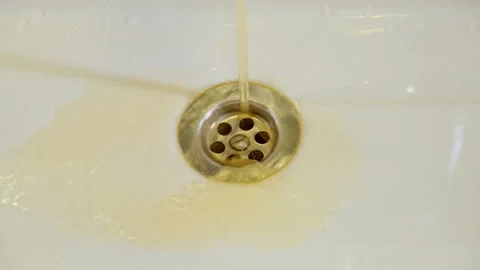 Rusty liquid is trickling from the hole in the metal sink, making it clear that Stock Footage 244456818