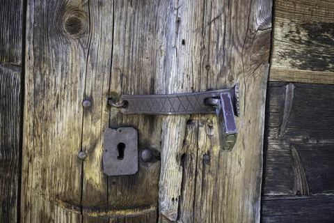 A rusty lock and key are on a wooden door Stock Photos