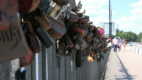 Rusty locks left by newly married couples hang on the bridge Stock Footage 99538877