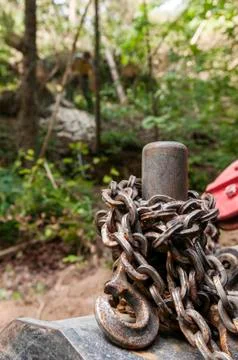 Rusty logging chain and forestry worker in background Stock Photos