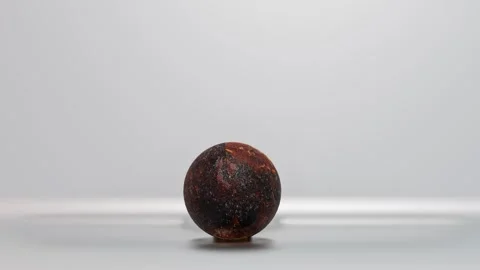 Rusty metal ball made of textile rolls from right to left on silver background.  Stock Footage 300845011
