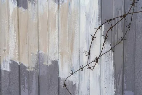 Rusty metal barbed wire on grey painted fence Stock Photos
