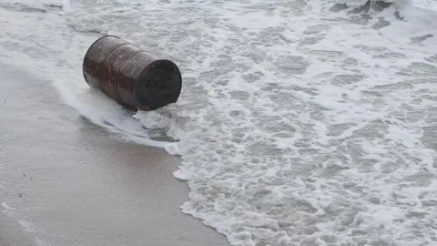 Rusty metal barrel in waves on seashore Stock Footage 304743406