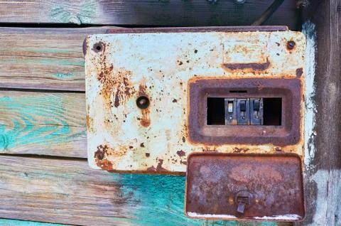Rusty metal box with electrical circuit breakers. Stock Photos