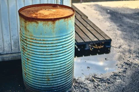 Rusty metal drum in an indrustrial area. Stock Photos